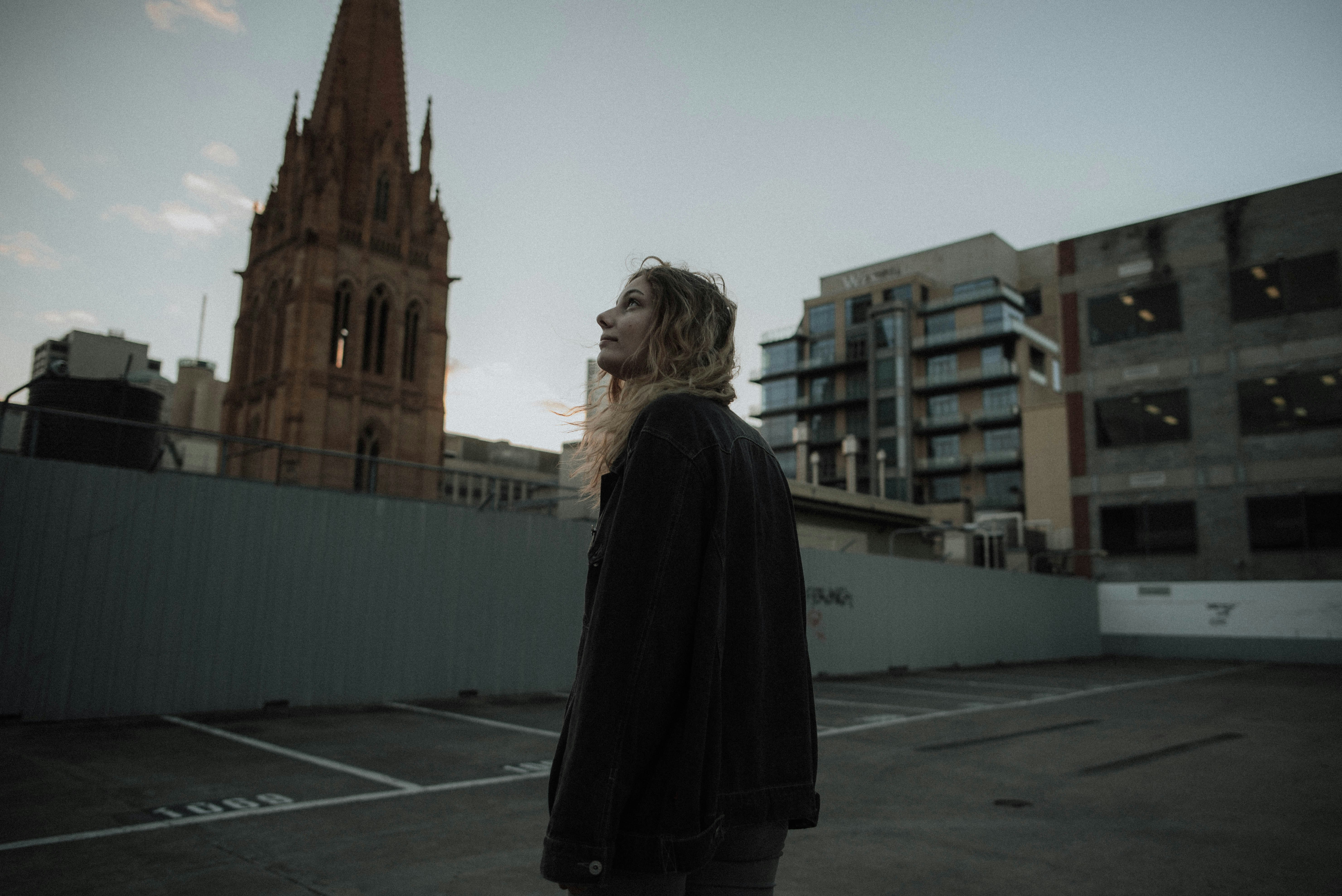 woman standing near cathedral looking at sky